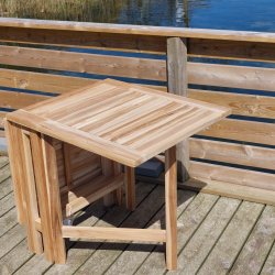 Foldbart teakbord med to sorte stabelstole i UV-beskyttet polyrattan