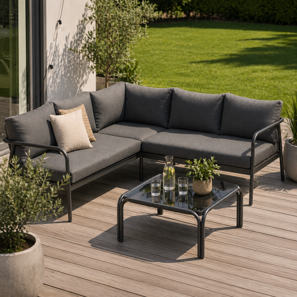 Moderne hj�rnesofa lounges�t i aluminium med bl�de vejrbestandige hynder og stilrent glasbord